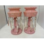 A pair of rose pink glass table lustres, the bowls enamelled with flower sprays and set with