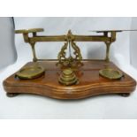A set of antique postage scales and weights, brass on a shaped mahogany base, 32cm max