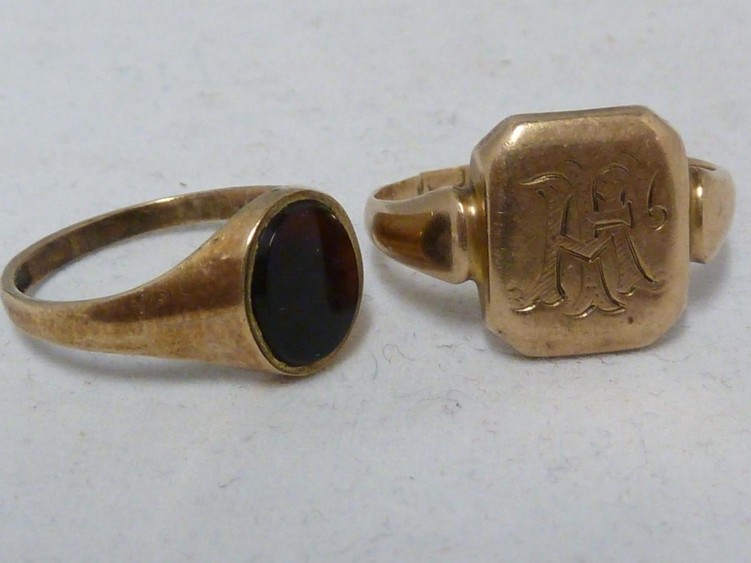 Two yellow gold signet rings, one marked 9ct and set with an oval black stone, ring size L 1/2,