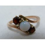 A opal and garnet ring, set in rose coloured metal, unmarked, ring size K; and two opal set