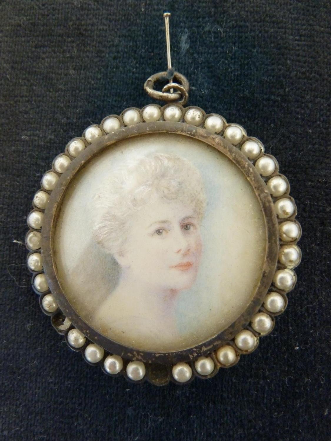 A portrait miniature of a woman, within a circular white metal frame set with half 'pearls', paper