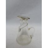 A Whisky noggin, the cut glass flask shaped jug mounted in silver with flip up lid, thumbpiece and