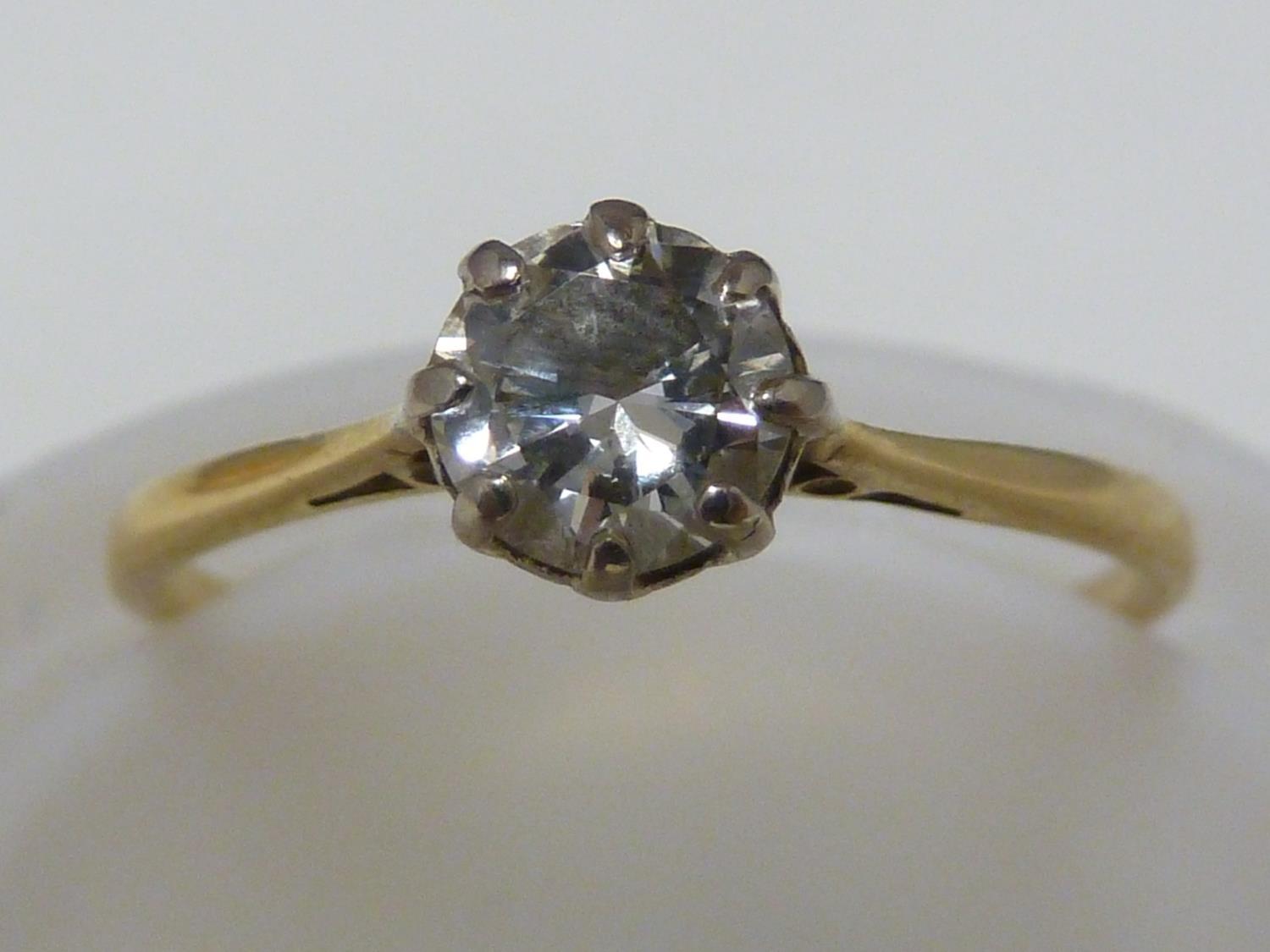 A solitaire diamond ring, the single round diamond of approx 0.5 carat set in an unmarked yellow