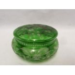 Stevens and Williams - an intaglio cut glass powder bowl cover of green overlay cut through to
