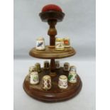Royal Crown Derby - a collectors full set of 15 porcelain thimbles on a wooden stand with pin
