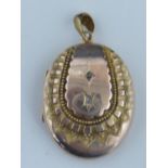 A Victorian two coloured gold metal and diamond locket, oval, decorated with a horseshoe shaped '