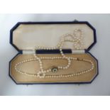 Two strings of cultured pearls with a 14ct yellow gold clasp, stamped 585, with presentation case,