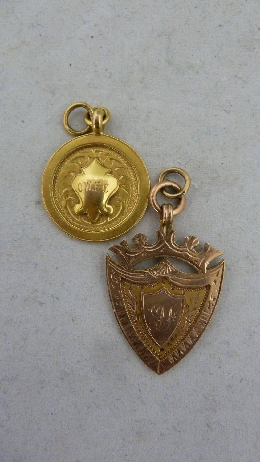 Two 9ct gold prize fobs, one rose gold, shield form, inscribed won by J Fulton for 'the best bird in