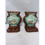 A pair of Chinese porcelain bookends, formed as flat backed porcelain wall vases on carved