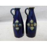 A pair of Royal Doulton stoneware miniature jugs, each with high placed strap handle and decorated