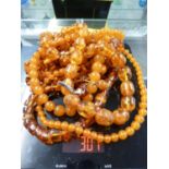 Various items of amber set jewellery comprising: two graduated round bead necklaces with screw