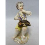 A Meissen porcelain figure, of a seated boy eating grapes, on foliate scroll base, blue crossed