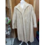 A cream 3/4 length mink coat, with leather bow details to cuffs, size 10 approx
