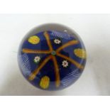 Paul Ysart - a glass paperweight, blue ground, decorated with a star of orange twist canes, 7.5cm
