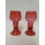Possibly James Powell & Sons, Whitefriars Limited - a pair of cranberry glass small size roemers,