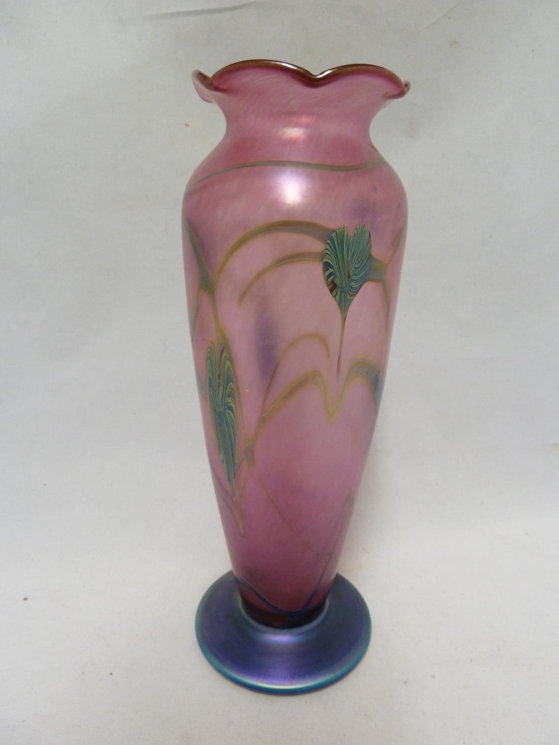 Okra - a glass vase, of pink bullet shaped body with frilled rim and circular blue glass foot, the