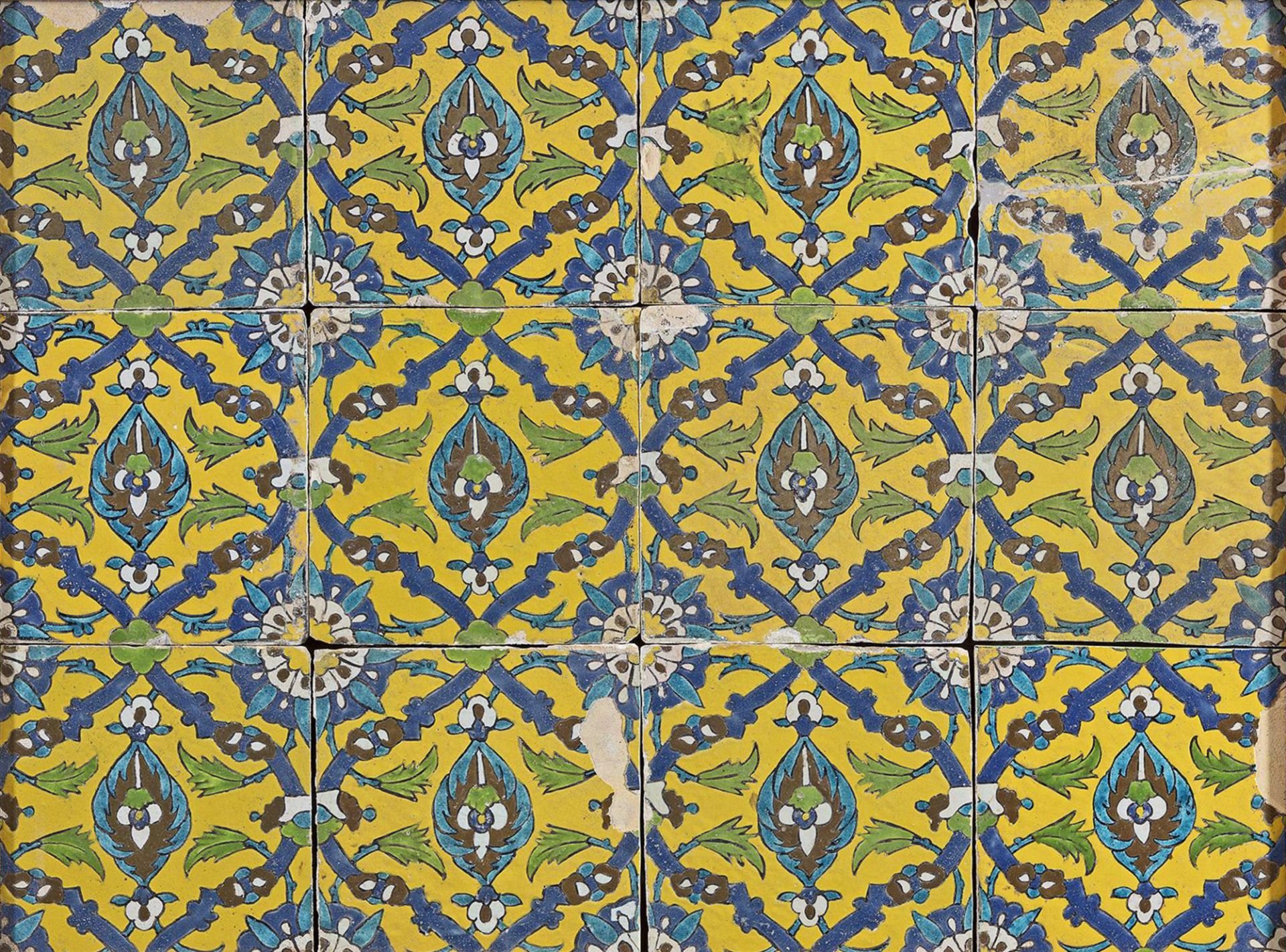 TWELVE YELLOW GROUND SAFAVID TILES MOUNTED IN A FRAME