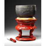 A JAPANESE TEMPLE BELL ON RED LACQUERED STAND WITH PILLOW