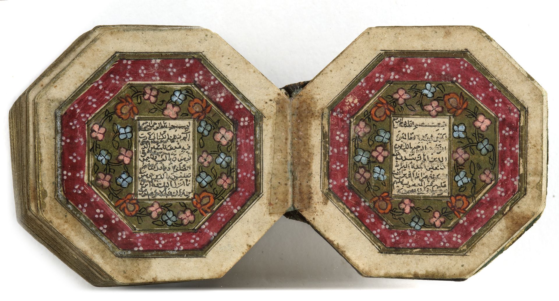 AN ILLUMINATED MINIATURE OCTAGONAL QURAN WITH THE LATER EMBOSSED NAME OF THE OWNER, AHMAD DHU'L KIFL