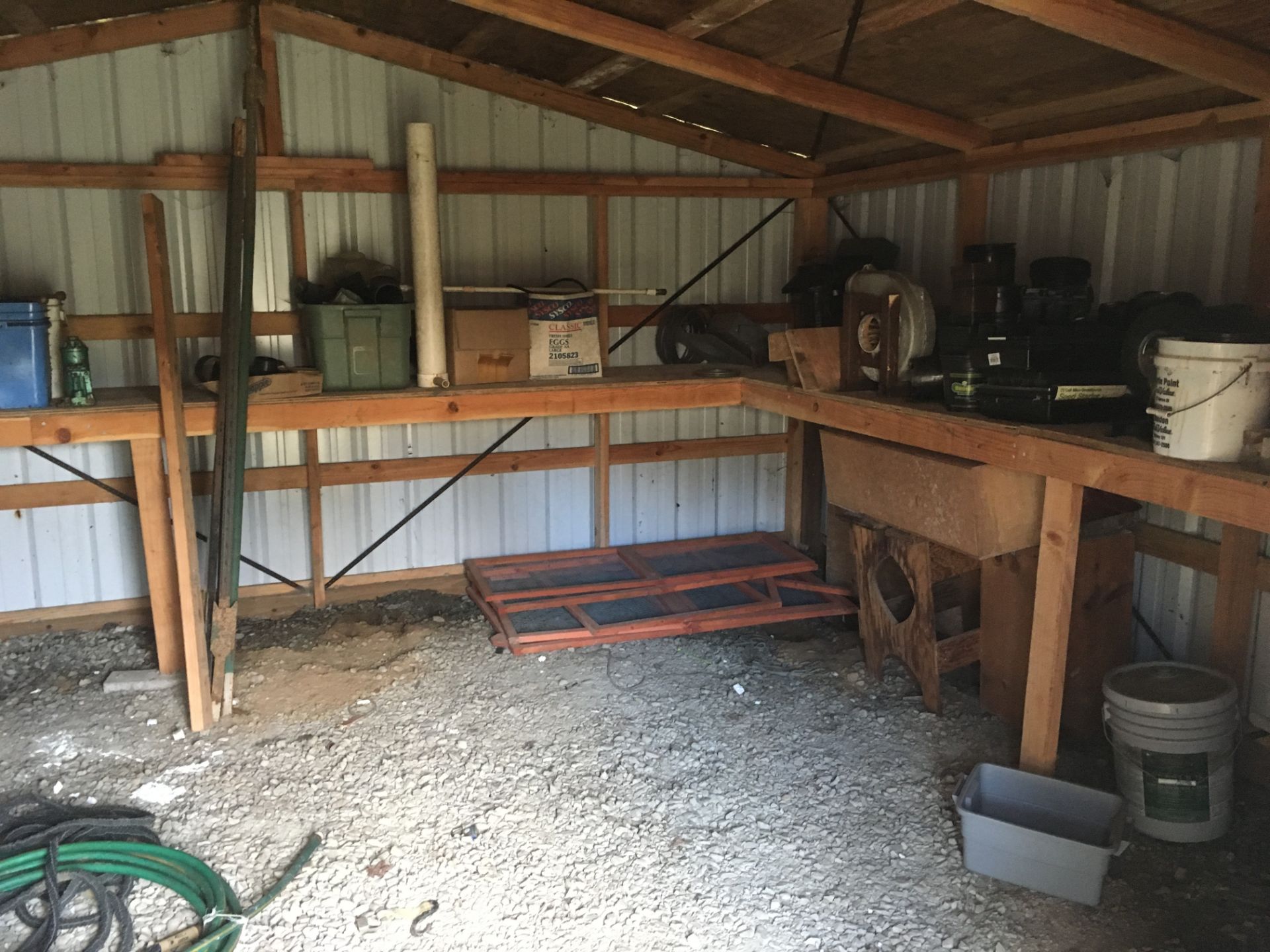 Contents inside shed including 2 gas cans, bug lamp, electric trimmer, screens, pallets etc.