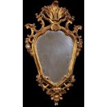 20th Century Italian School. A Carved Giltwood Florentine Frame, with inset mirror glass, Shaped,