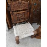 An antique Arabic bird foliage carved back chair with weaved design base.