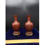 Pair of Early Chinese Cinnebar vases depicting gheisha scene signed to base. sat up on fruit Wood