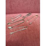 Lot of 4 silver Hall marked tongs together with contential white metal tongs.