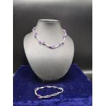 Silver necklace bracelet set in purple design.