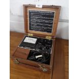 Vintage volt testing machine with wooden casing.
