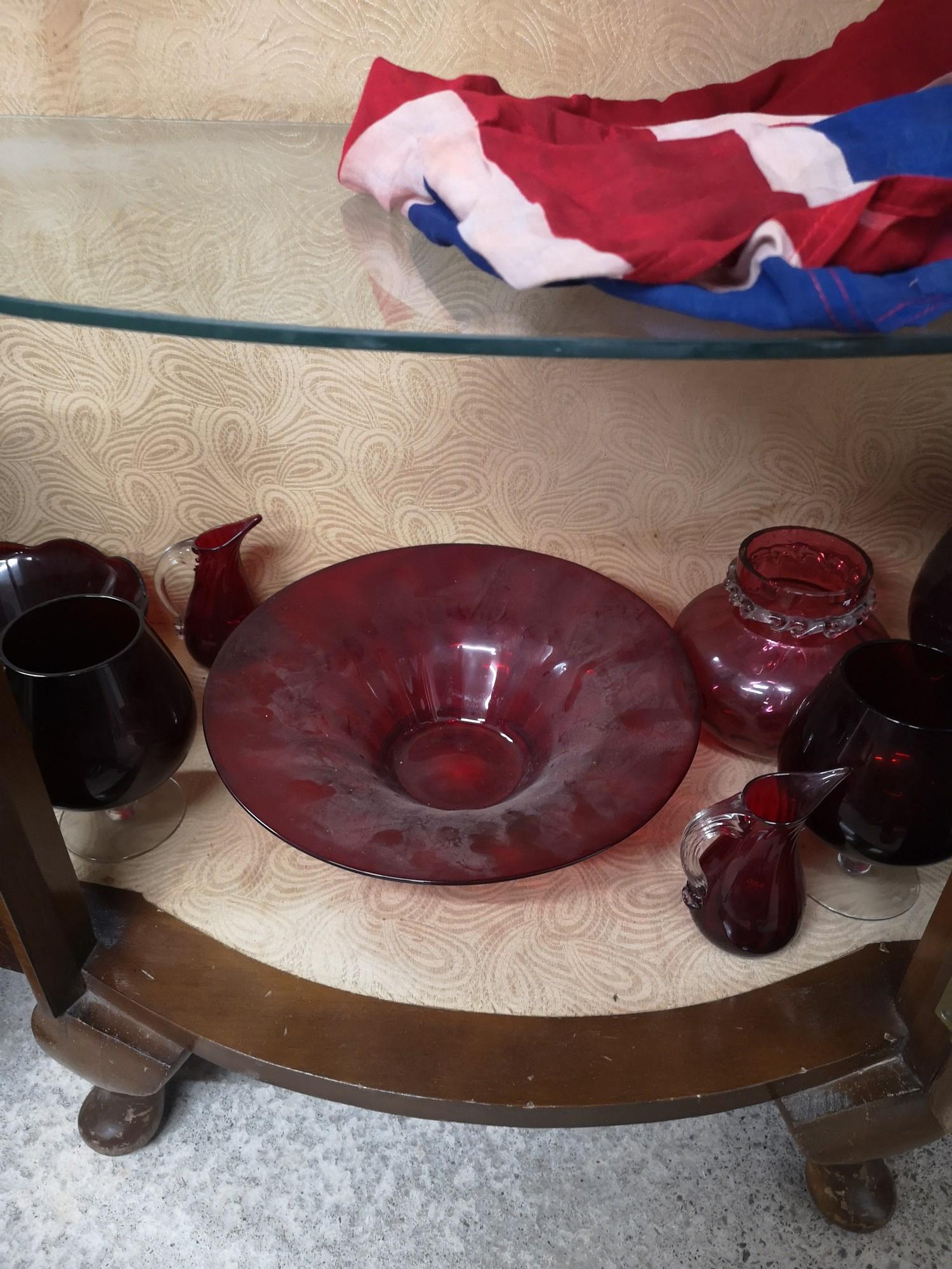 Shelf of cranberry glass.