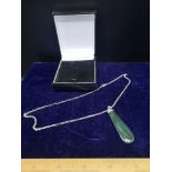 Silver chain on green stone dropped pendant.