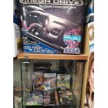 Sega mega drive console with shelf of Sega mega drive games.