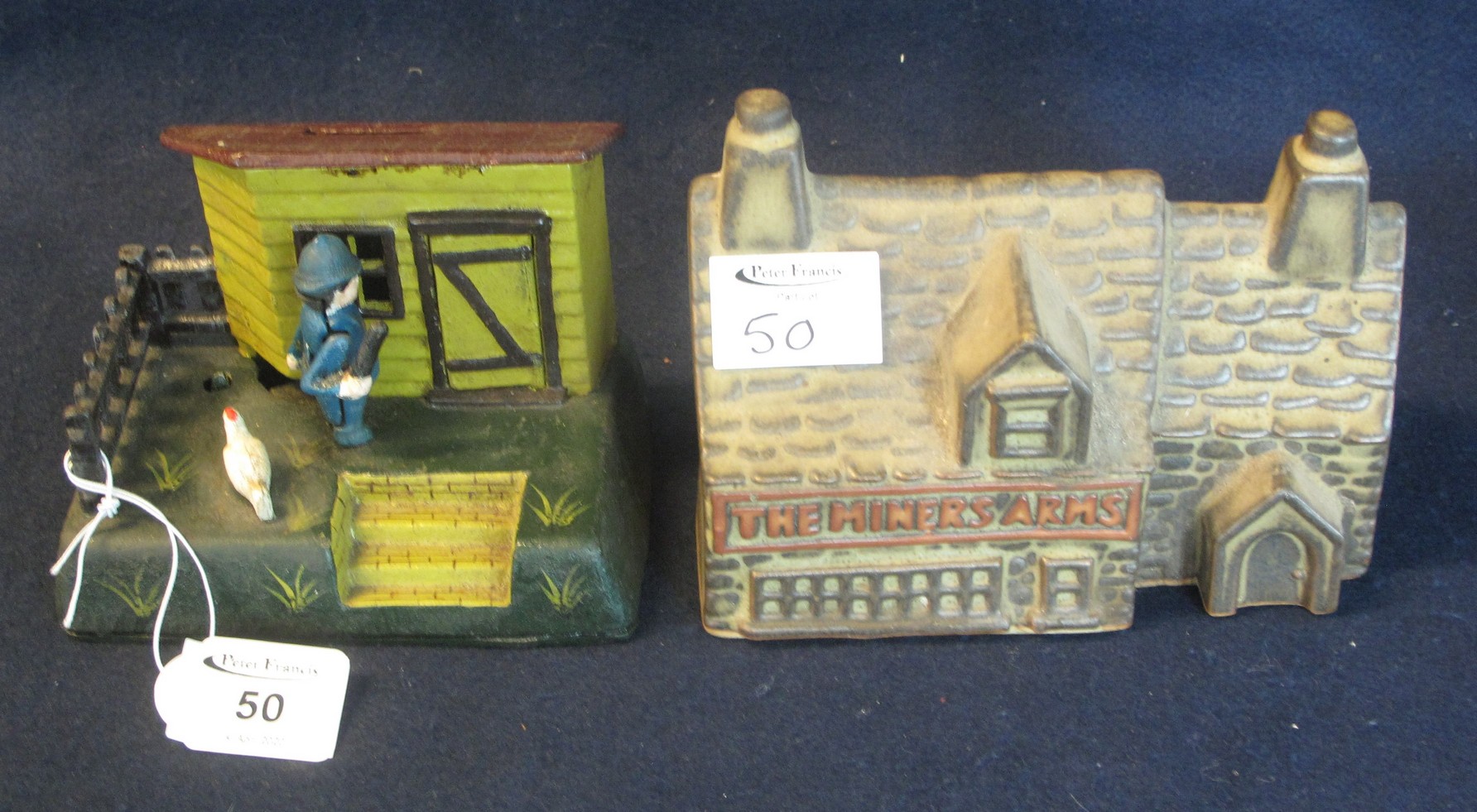 A reproduction cast metal moneybox and a ceramic Miner's Arms stoneware moneybox. (2) (B.P. 24%