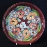 Modern Moorcroft art pottery tube lined cabinet plate or charger, overall on a red ground with