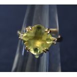 A yellow stone dress ring set in 9ct gold with a diamond to each shoulder, approx weight 3.7g.