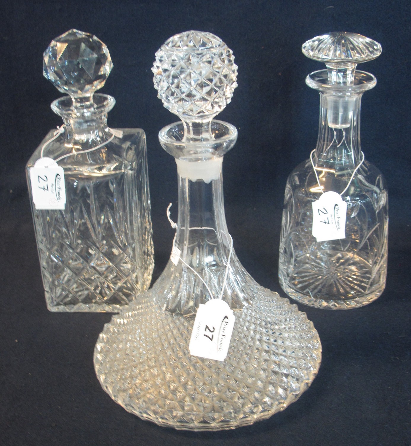 Three glass decanters of varying forms including mallet shaped and a ship's type decanter, all