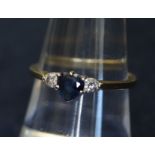 An 18ct gold sapphire and diamond ring, central heart shaped sapphire flanked on either side by a