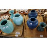 Two trays of Royal Lancastrian vases on blue and turquoise grounds, including a pair of baluster