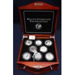 Cased set of assorted uncirculated silver coins, various countries, in simulated wooden lockable