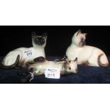 Two Beswick studies of Siamese cats, together with a similar Royal Doulton Siamese cat, shape no.