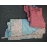 Two vintage quilts, one pink to one side and blue to reverse, the other pale blue and floral with