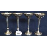 A set of four very similar silver trumpet vases with C scroll rims and circular loaded bases. All