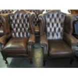 Two similar modern burgandy button back chesterfield style wing armchairs on cabriole legs. (2) (B.