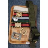 A collection of military webbing belts, various including; Royal Logistic Corps (2), blanco'd belt