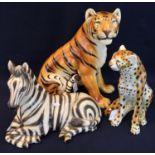 Three ceramic continental figurines to include; recumbent zebra, seated cheetah and an Italian