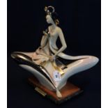 A Galos Portuguese Art Deco style figurine in a seated pose with unusual headdress and fan.
