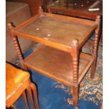 Early 20th Century oak two tier bobbin turned trolley on wheels. (B.P. 24% incl. VAT)