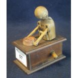 Small automaton type wooden figure on a box, the figure remotely operated with knob to the side