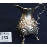 Silver baluster shaped cream jug with card cut rim, shaped loop handle, repousse foliate